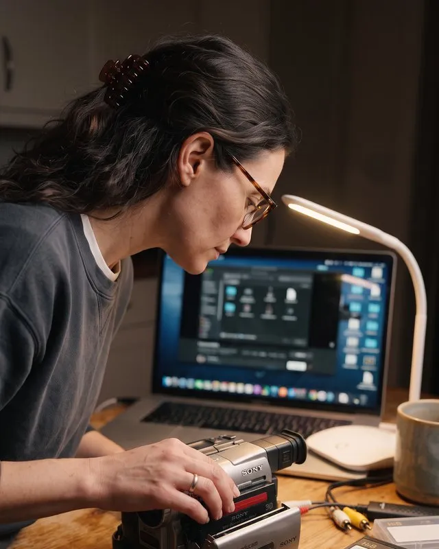 Lena Adler at her desk, loading one of Cass's Hi8 tapes